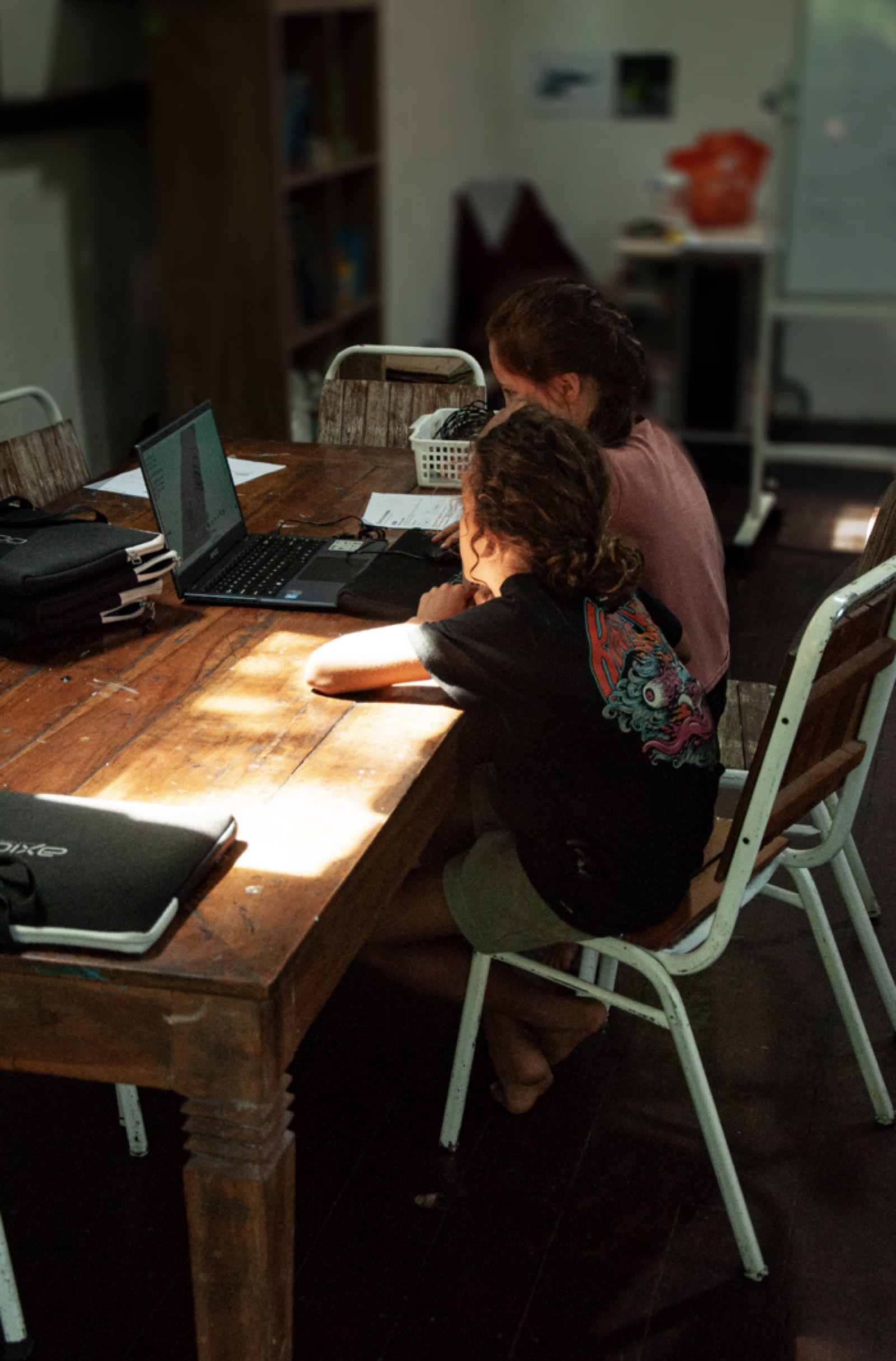 Students collaborating on a laptop project at Wisdom Academy